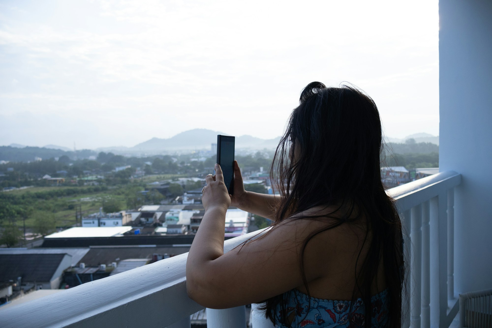A guest using a phone on a hotel balcony