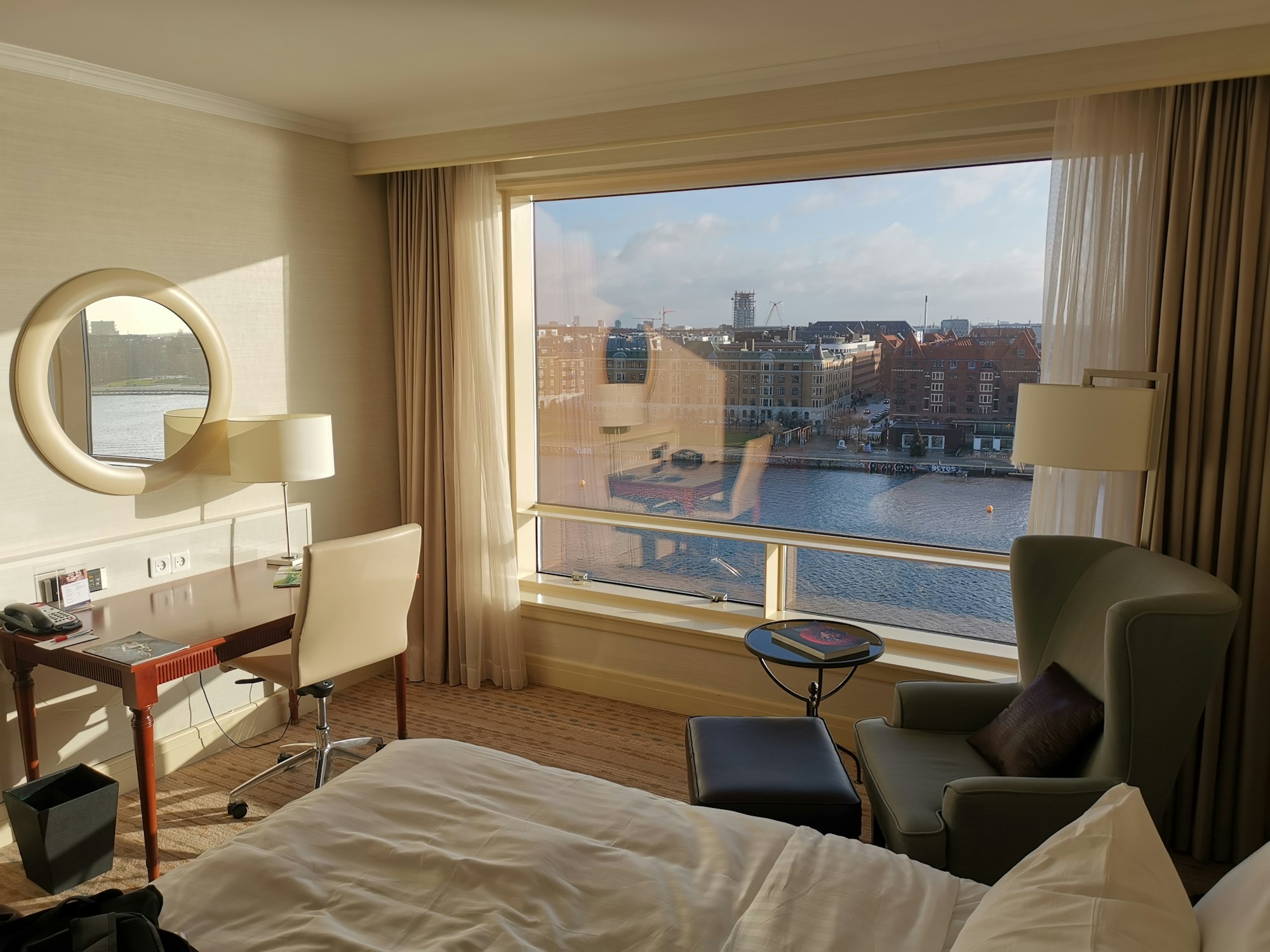 A made-up hotel room in morning light